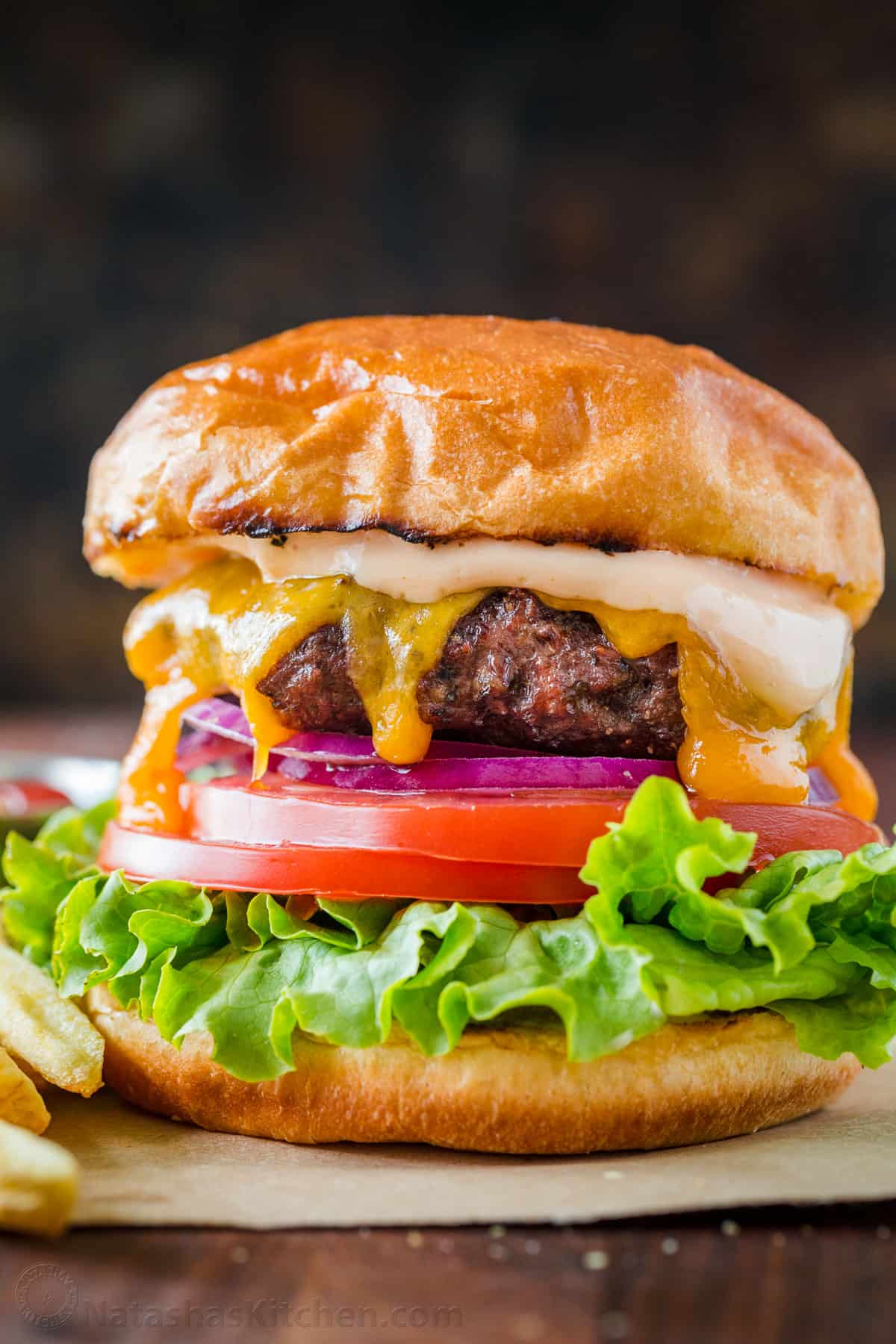 Cheeseburger with sauce, lettuce, tomato, onion and toasted bun