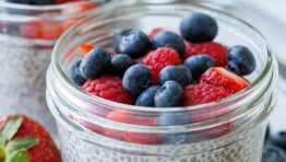 Simple chia seed pudding recipe in mason jars with berries on top