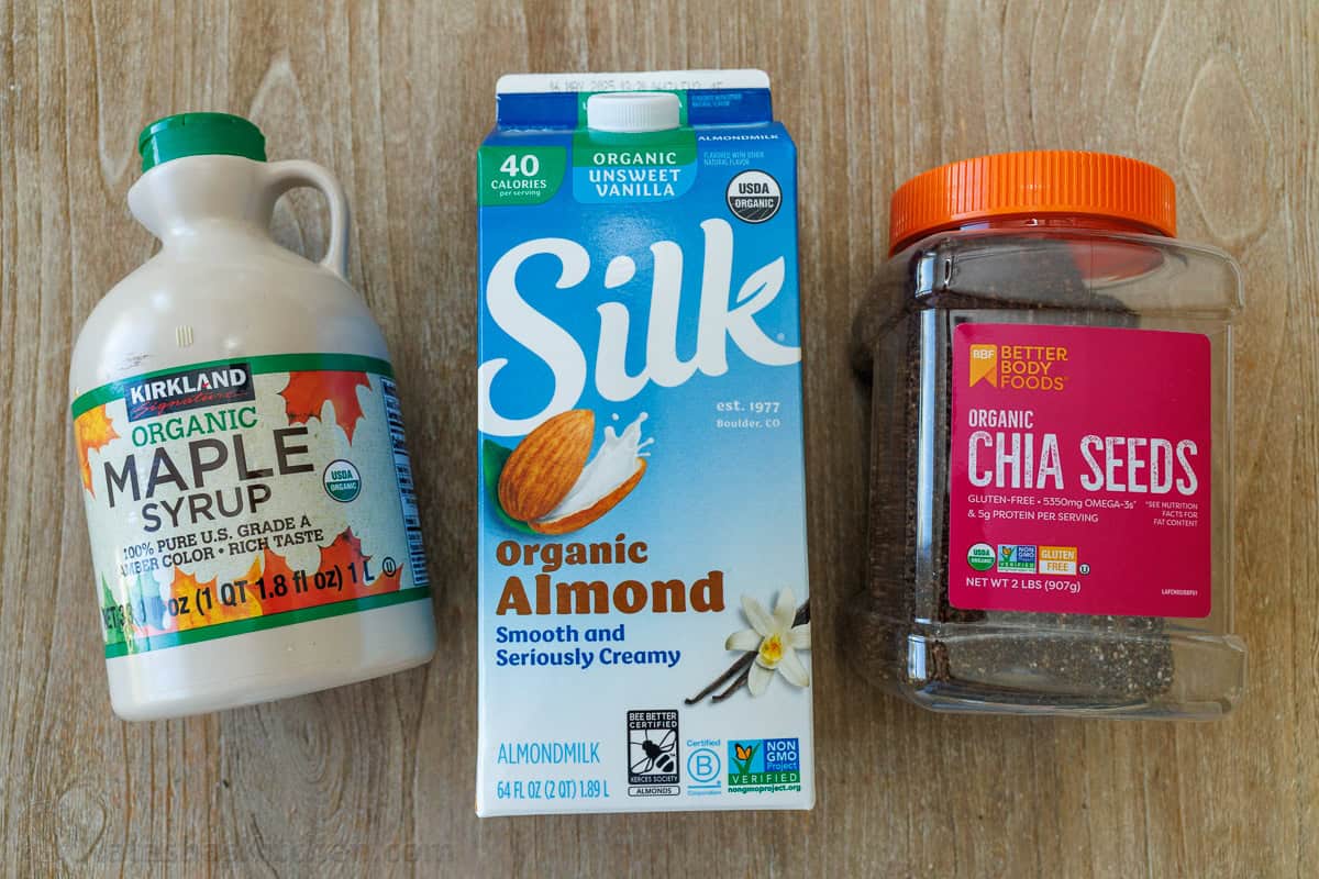maple syrup, silk almond milk and chia seeds on a wooden table