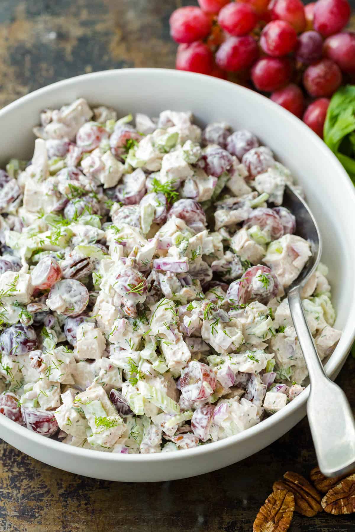 Chicken salad in mixing bowl garnished with dill