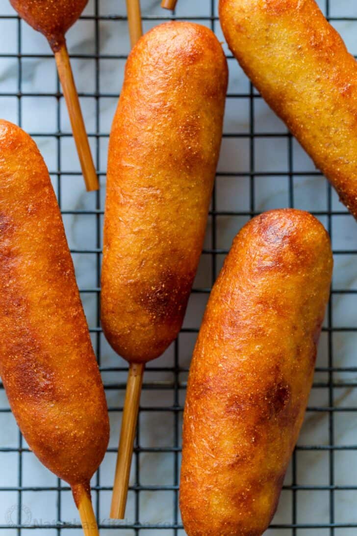 corn dogs cooling on a wire rack
