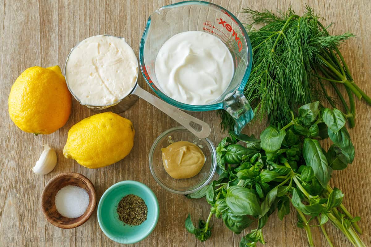 Ingredients for Green Goddess Dressing including lemon, garlic, Greek yogurt, Mayo, Dijon mustard, salt, pepper, basil and dill