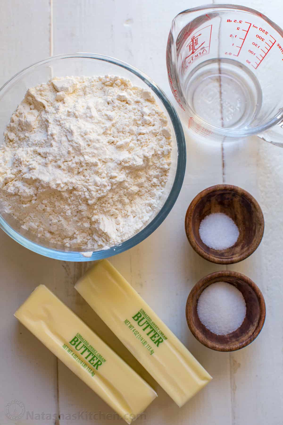 This homemade Pie Crust recipe yields a flaky, tender crust with rich buttery flavor. An easy pie dough - perfect for sweet or savory pies. Ingredients for homemade pie crust with flour, water, salt, sugar and butter.