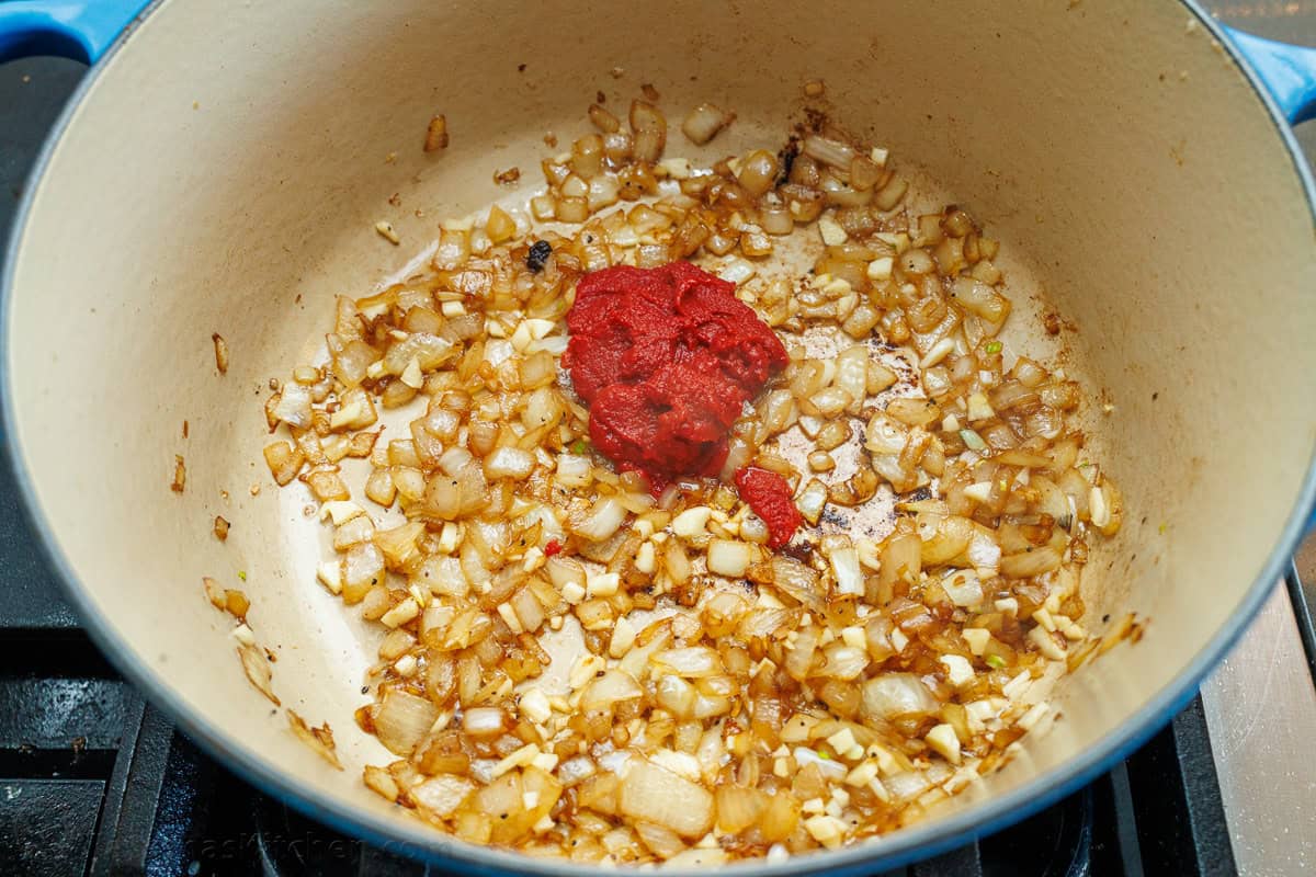 Onions and garlic in a dutch oven with tomato paste