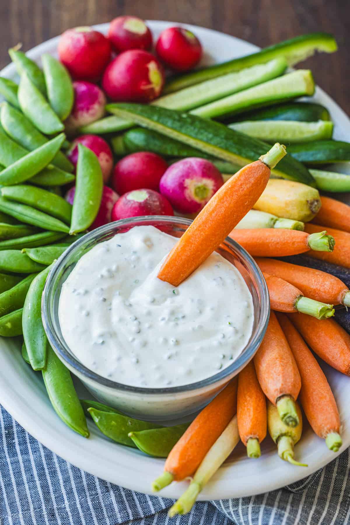 Oval veggie tray with carrot dipped into sour cream dressing
