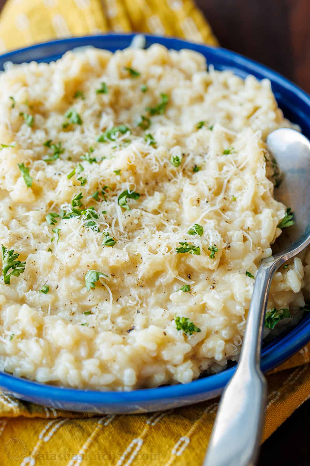 Risotto in blue bowl garnished with parmesan and parsley