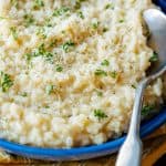 Parmesan risotto served in blue bowl garnished with parsley