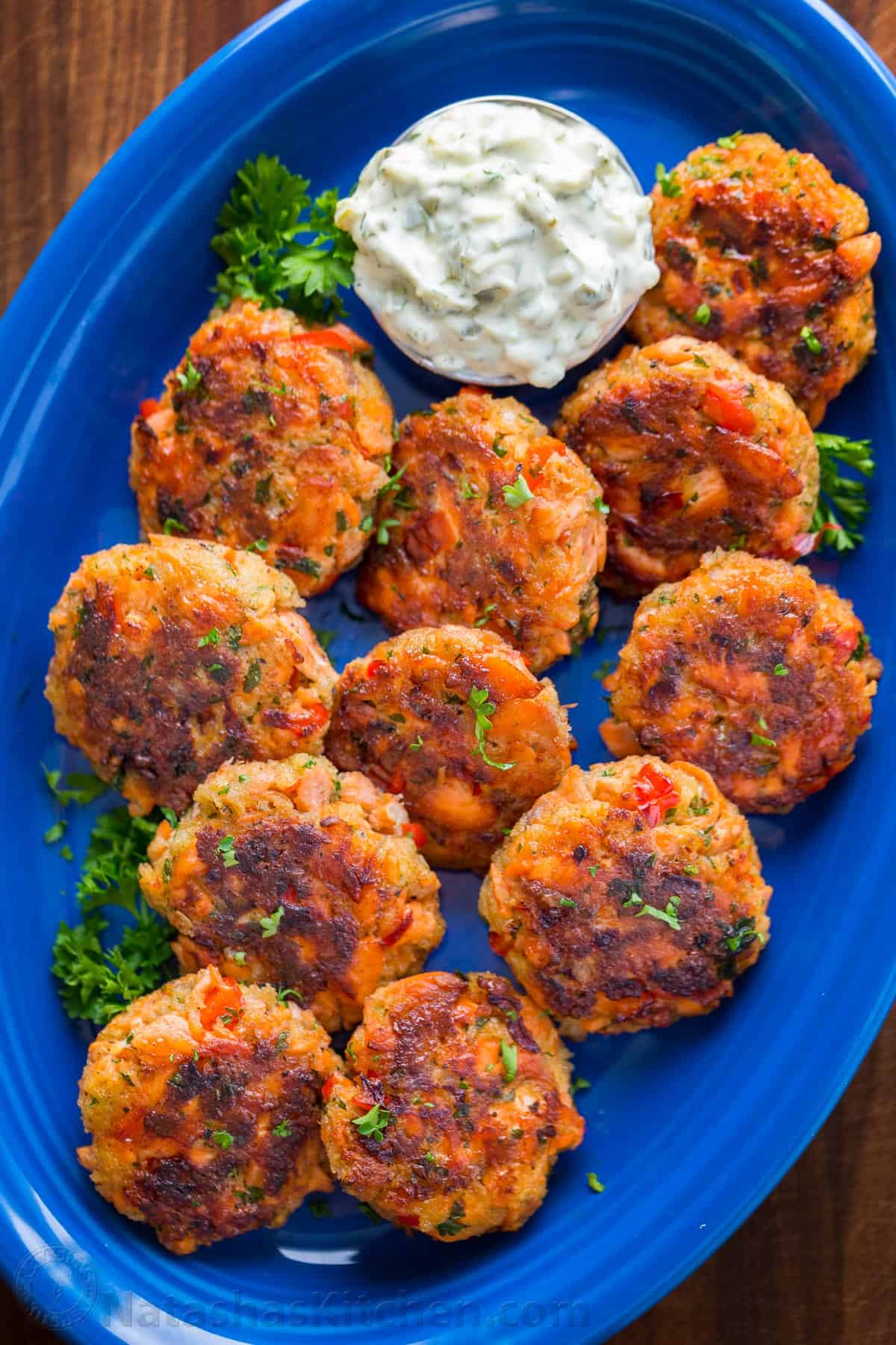 Salmon Patties on a plate with tartar dipping sauce.