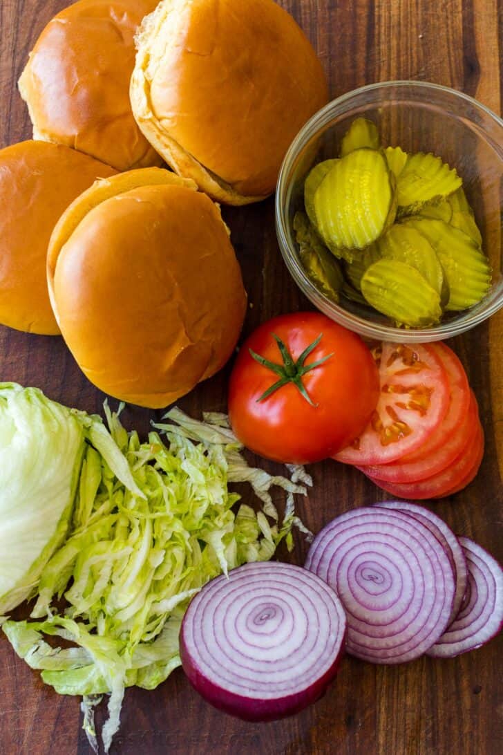 Smashburger toppings with buns, lettuce, tomatoes, pickles and onions