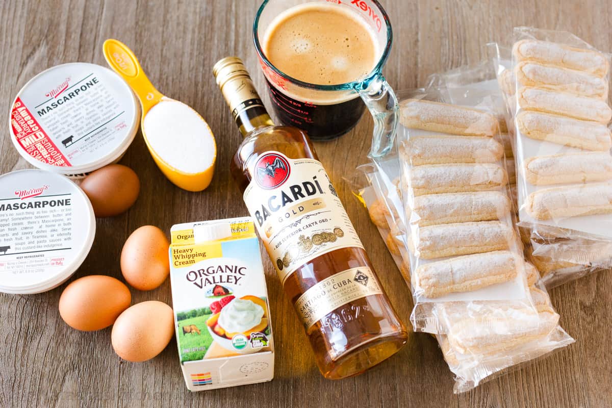 ingredients for Italian layered dessert including mascarpone cheese, eggs, sugar, heavy whipping cream, rum, coffee and ladyfingers