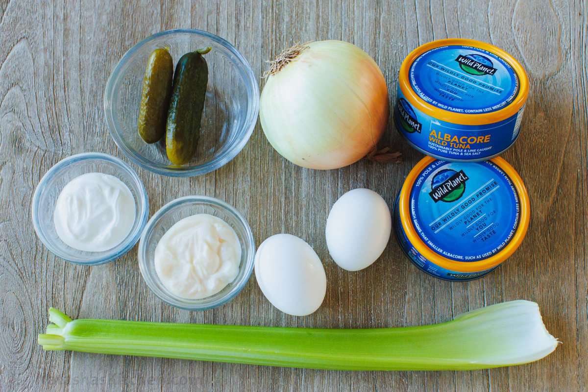 The ingredients for the best lunch recipe including canned fish, onion, hard-boiled eggs, mayo, sour cream, pickles, celery