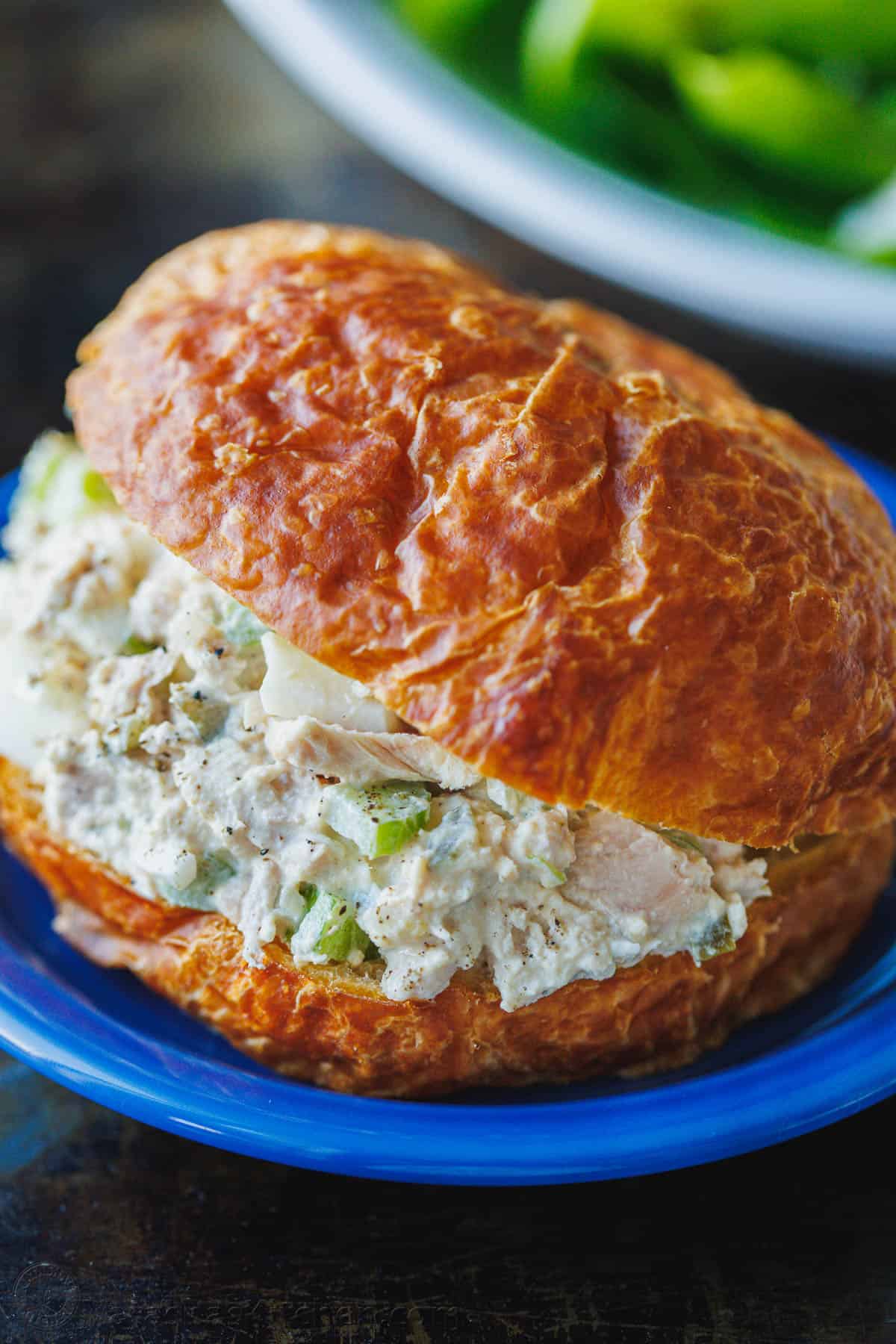 Tuna Salad served in a croissant on a blue plate